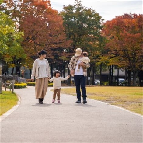 秋の昼間、公園を散策する親子4人家族